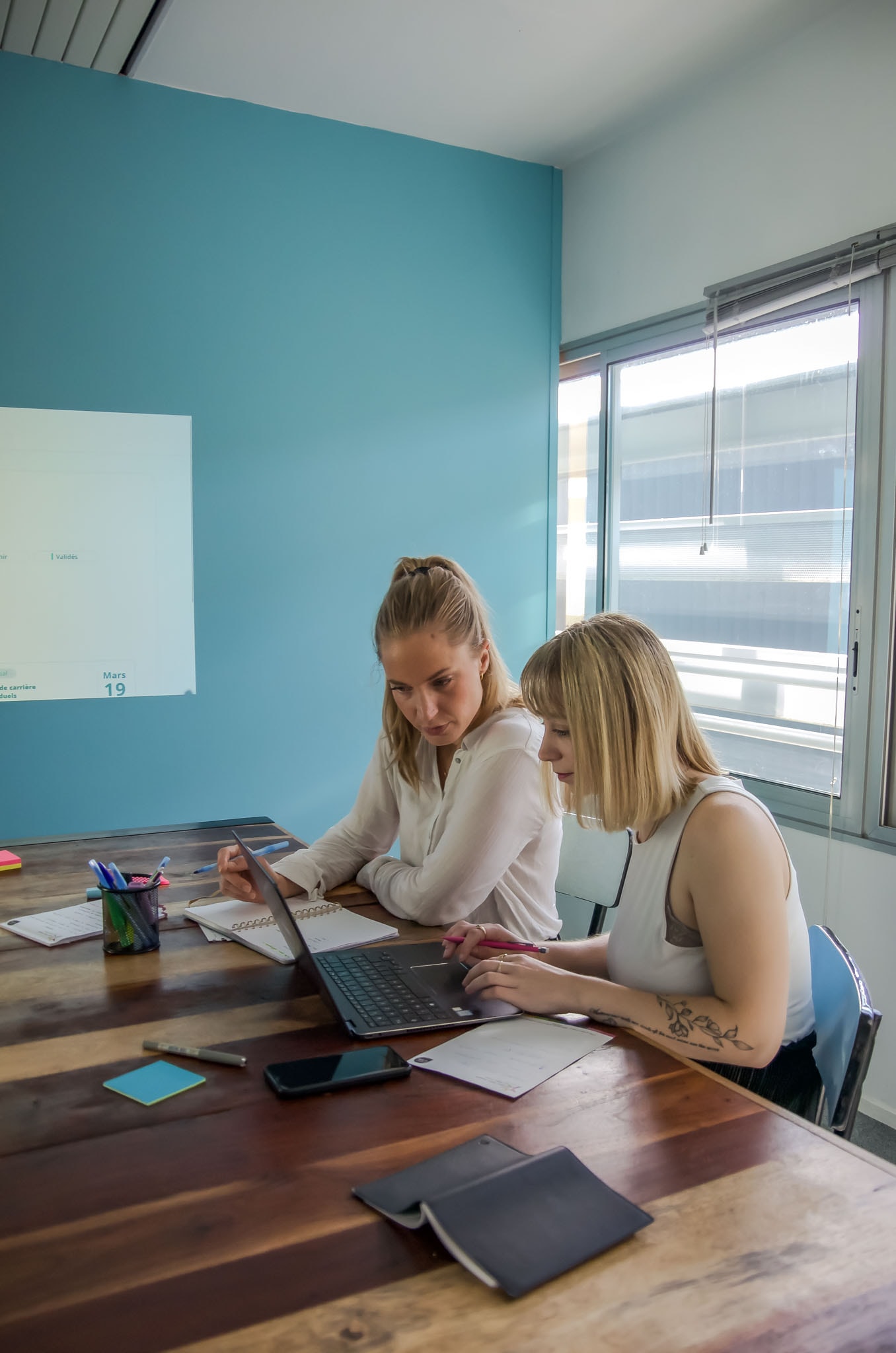 Deux membres de l'équipe Doddee au travail devant le logiciel.